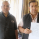 Two men holding a document.